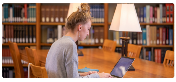 A student works at a laptop at a table in the Peterson Memorial 图书馆.